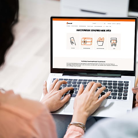 A couple is looking at the Mondi Group website on a PC.